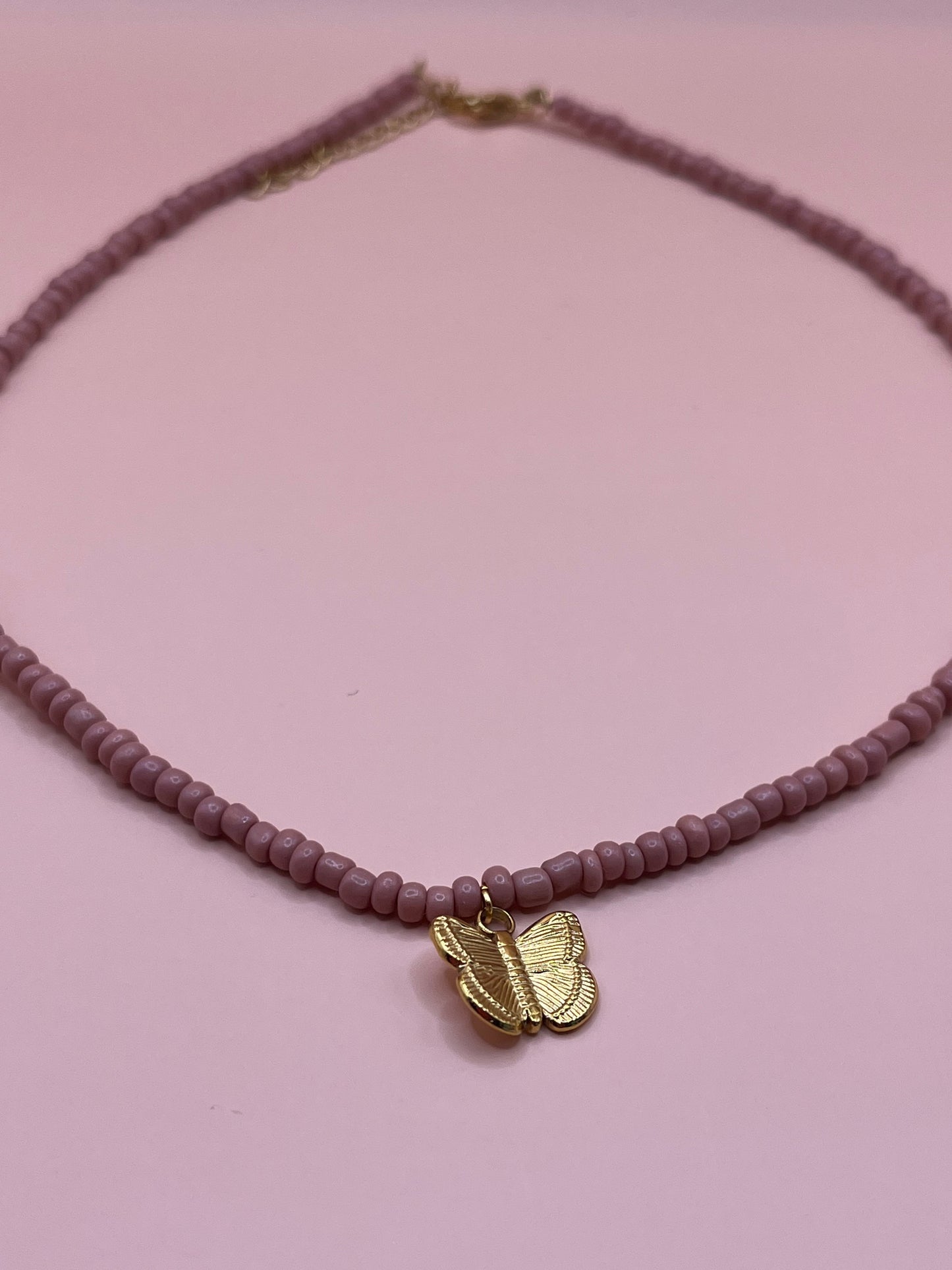 collier en perles papillon rose